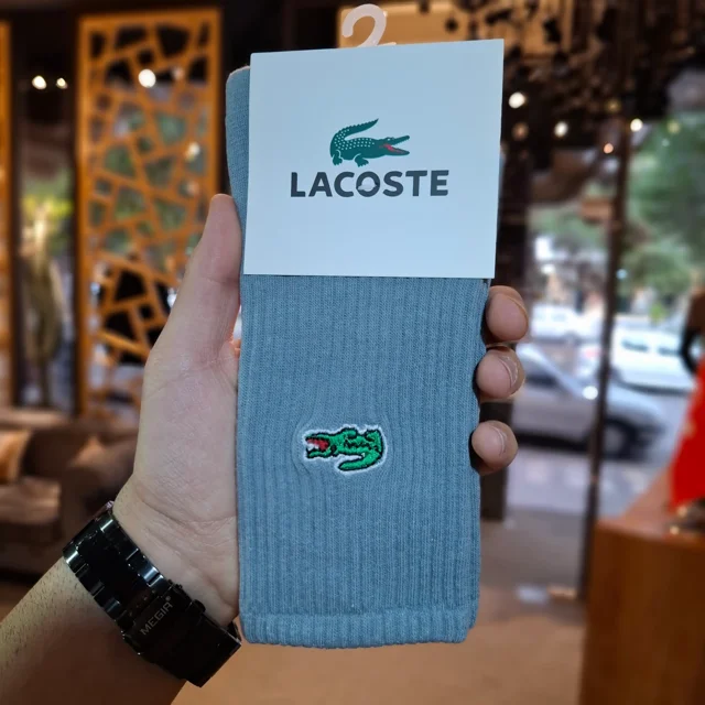 جزئیات دوخت و کیفیت گلدوزی لوگوی لاگوست روی جوراب ساقدار آبی طوسی